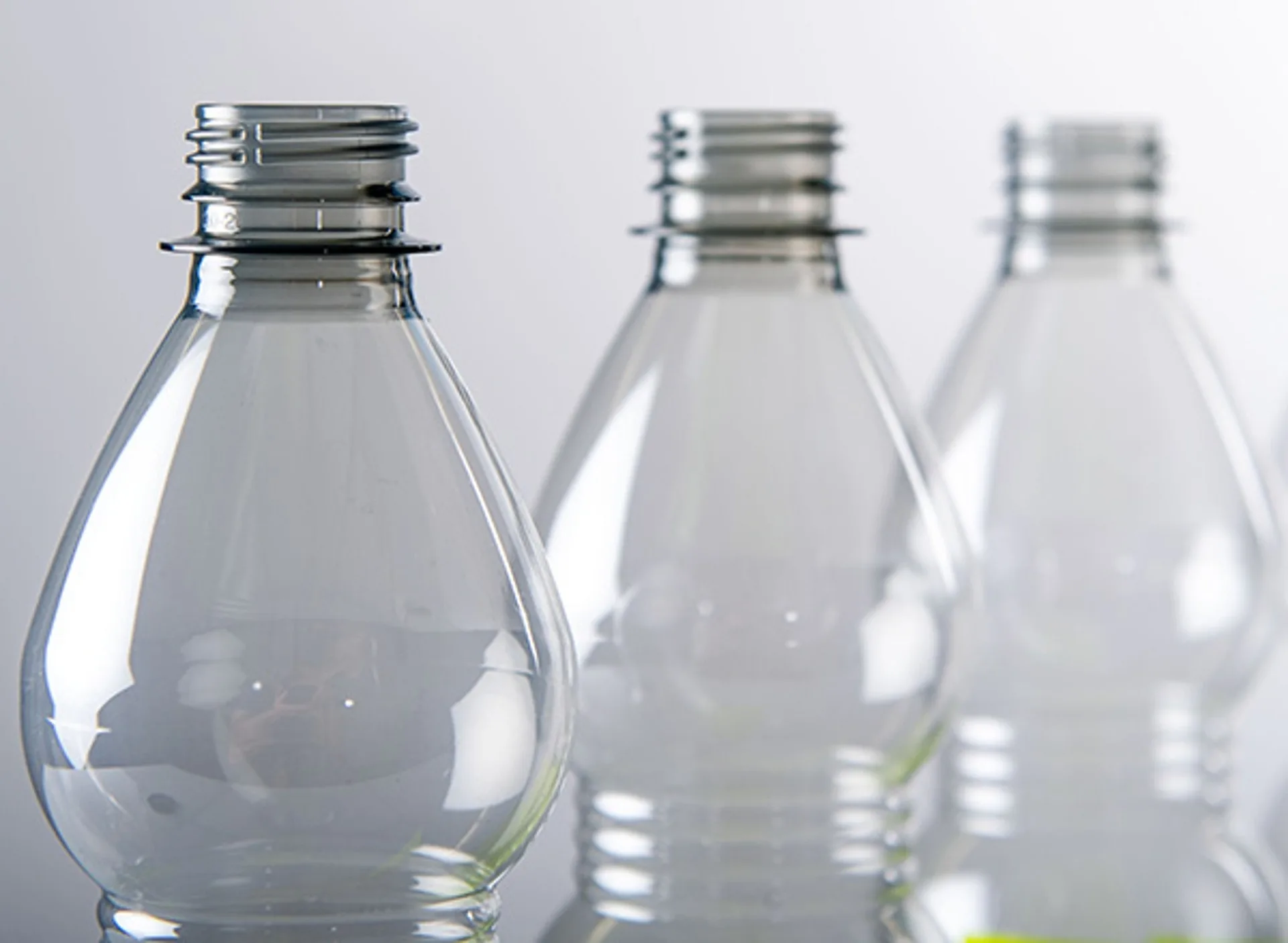 Three unlabelled clear bottles showing different neck finishes