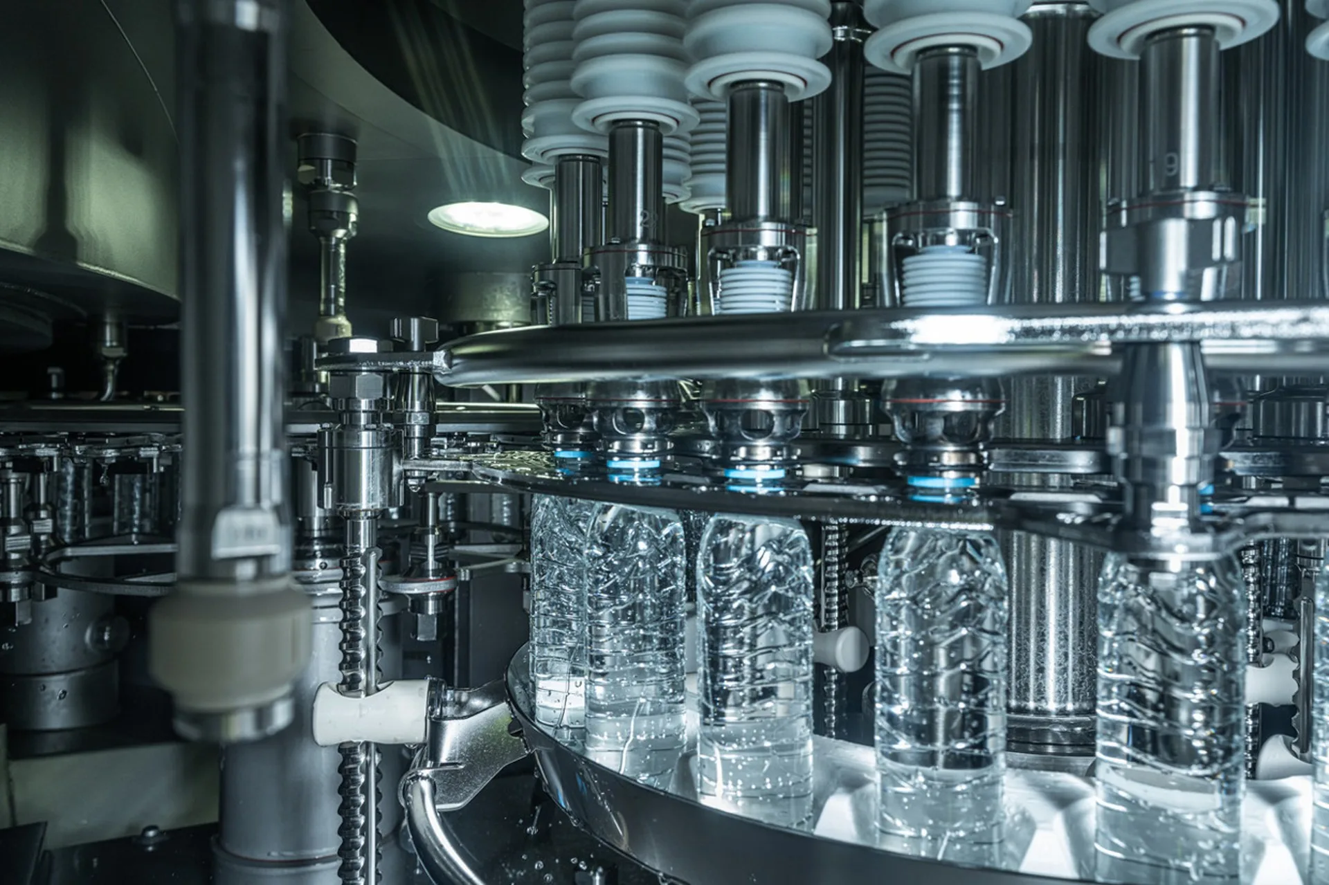Stainless steel filling heads processing clear PET bottles