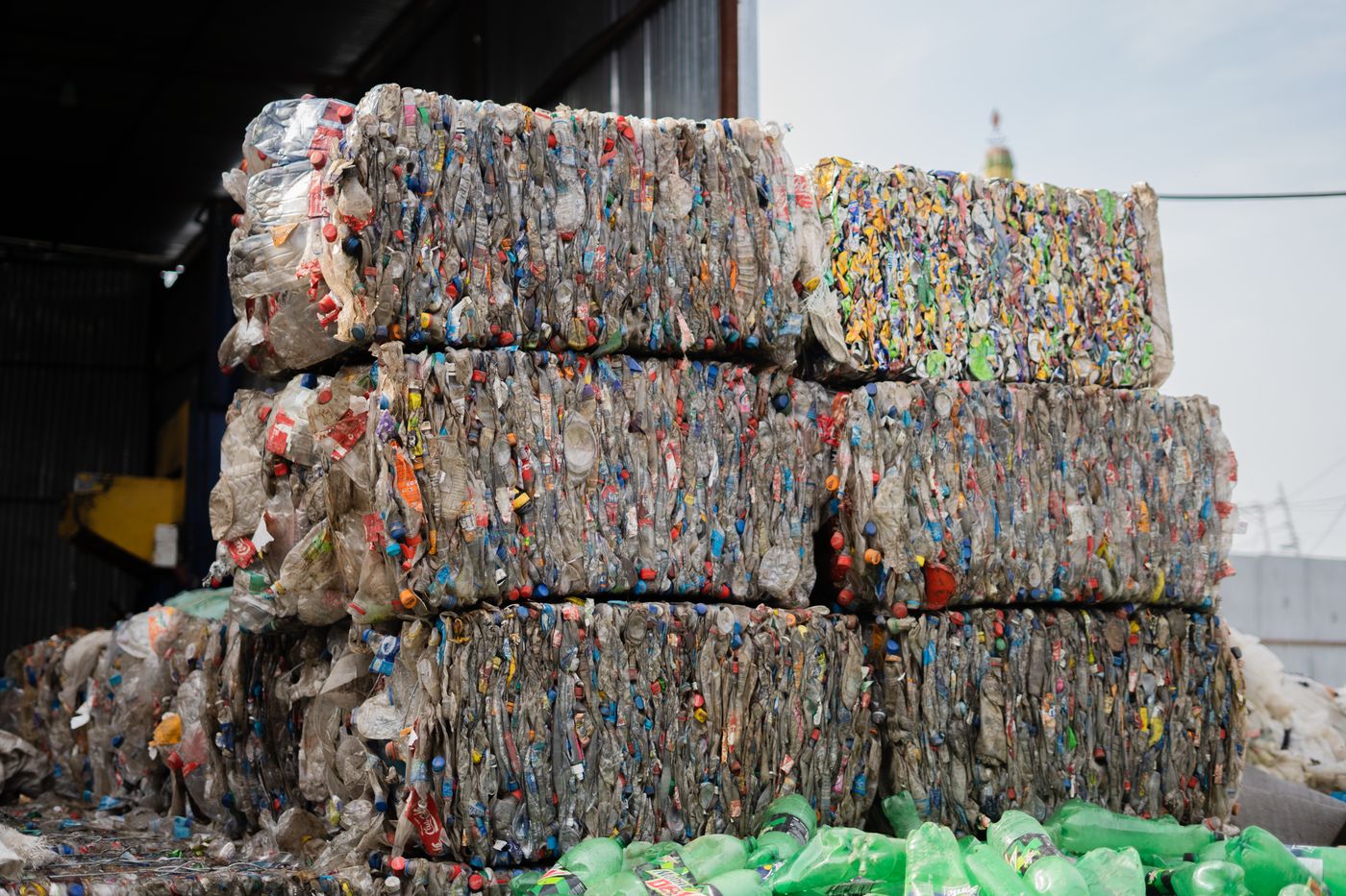 Compressed plastic bales stacked at a recycling facility